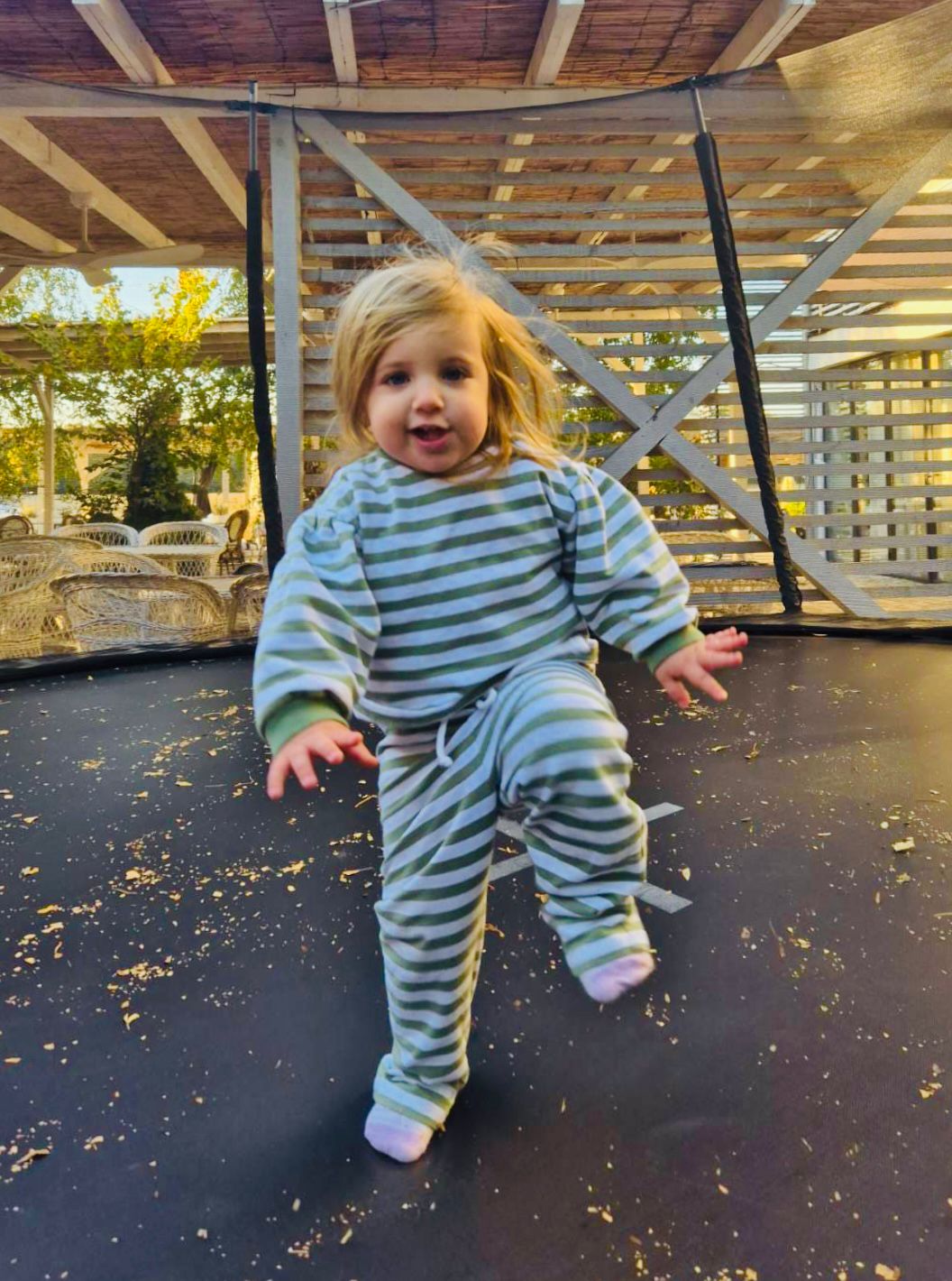 Bambina che indossa tuta a righe verdi e bianche completa